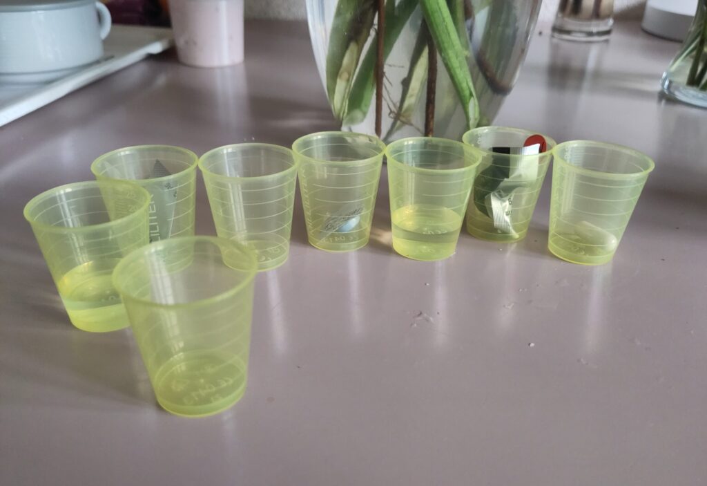 Viele kleine Einwegbecher für die Medikation einer Patientin, verteilt für jede Tablette einzeln – zeigt den hohen Verbrauch von Plastik im Klinikalltag.